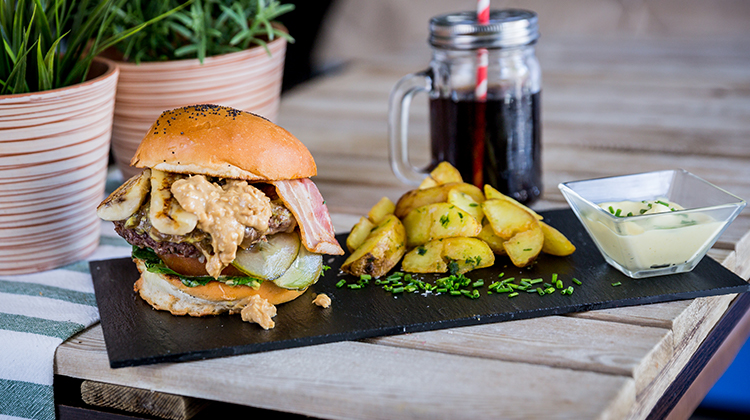 Nuevos platos veganos. Memphis burger: Hamburguesa de ternera con cebolla caramelizada, lechuga, tomate, pepinillo, bacon plátano a la plancha y crema de cacahuete como toque final. 